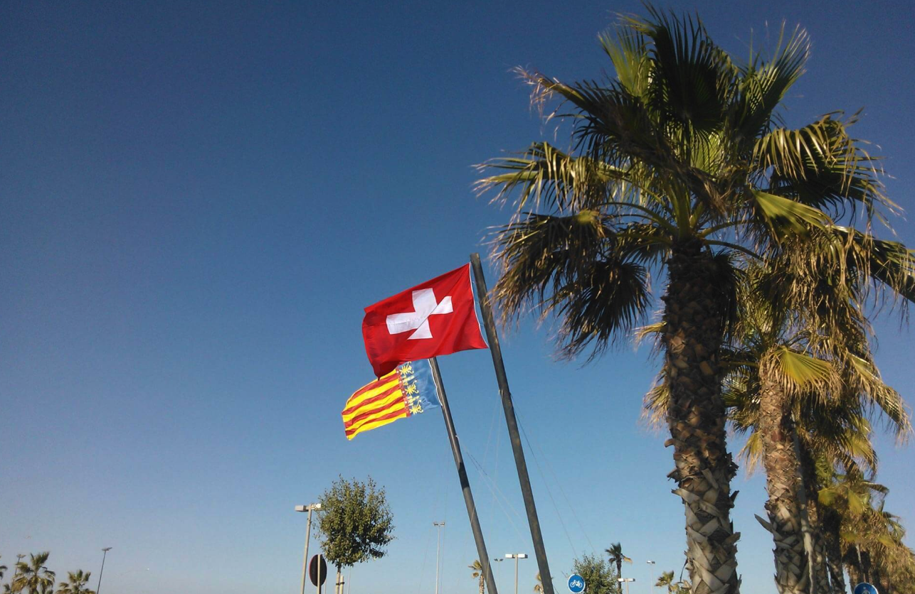 Schweizer und valencianische Flagge mit Palme an der Costa Blanca
